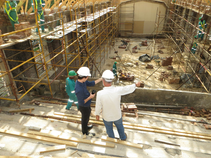 Odoo for construction man in white long sleeve shirt and blue denim jeans standing on white metal ladder